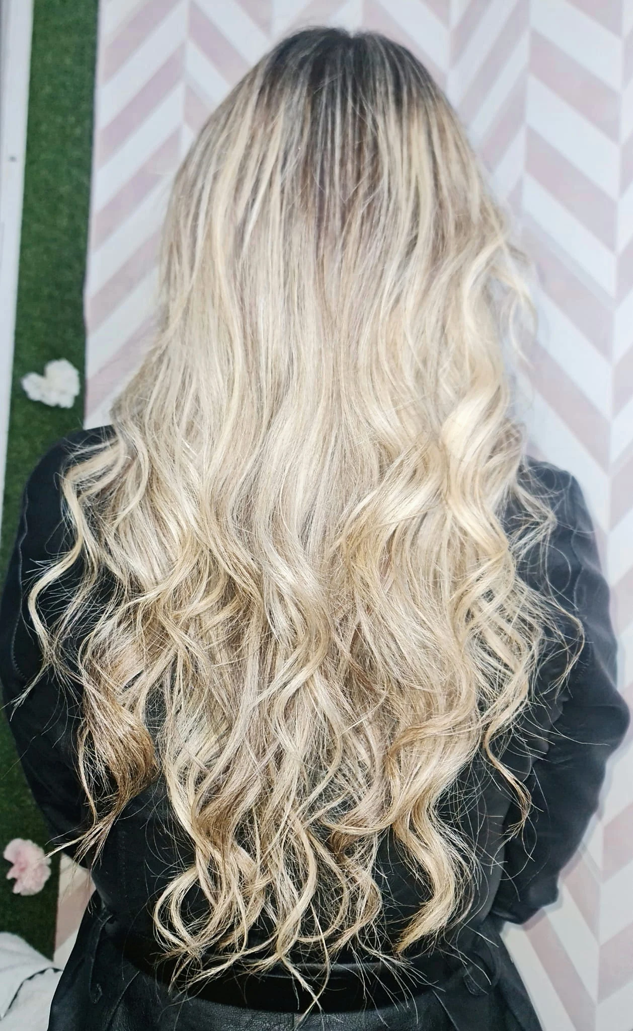 Resultado de correção de cor em cabelo loiro comprido e ondulado, visto de costas.